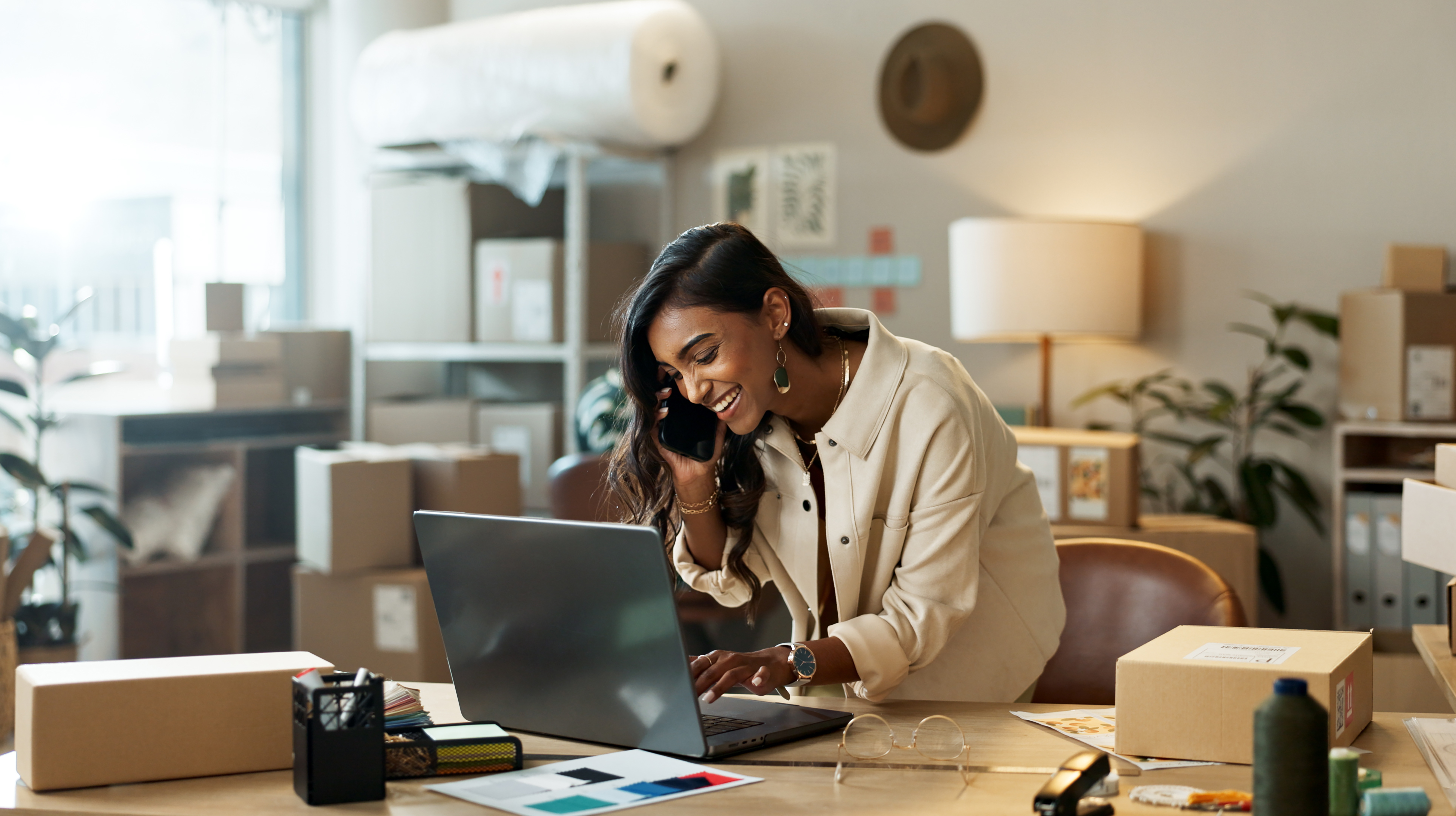 Telefonanruf, kleines Unternehmen oder glückliche Frau mit Laptop für E-Commerce-Kommunikation im Büro. Tippen, lächeln oder indische Managerin, die einem Gespräch zuhört oder über Neuigkeiten, Feedback oder Networking spricht.