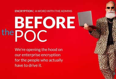 Man in a suit holding a laptop while giving the OK hand gesture